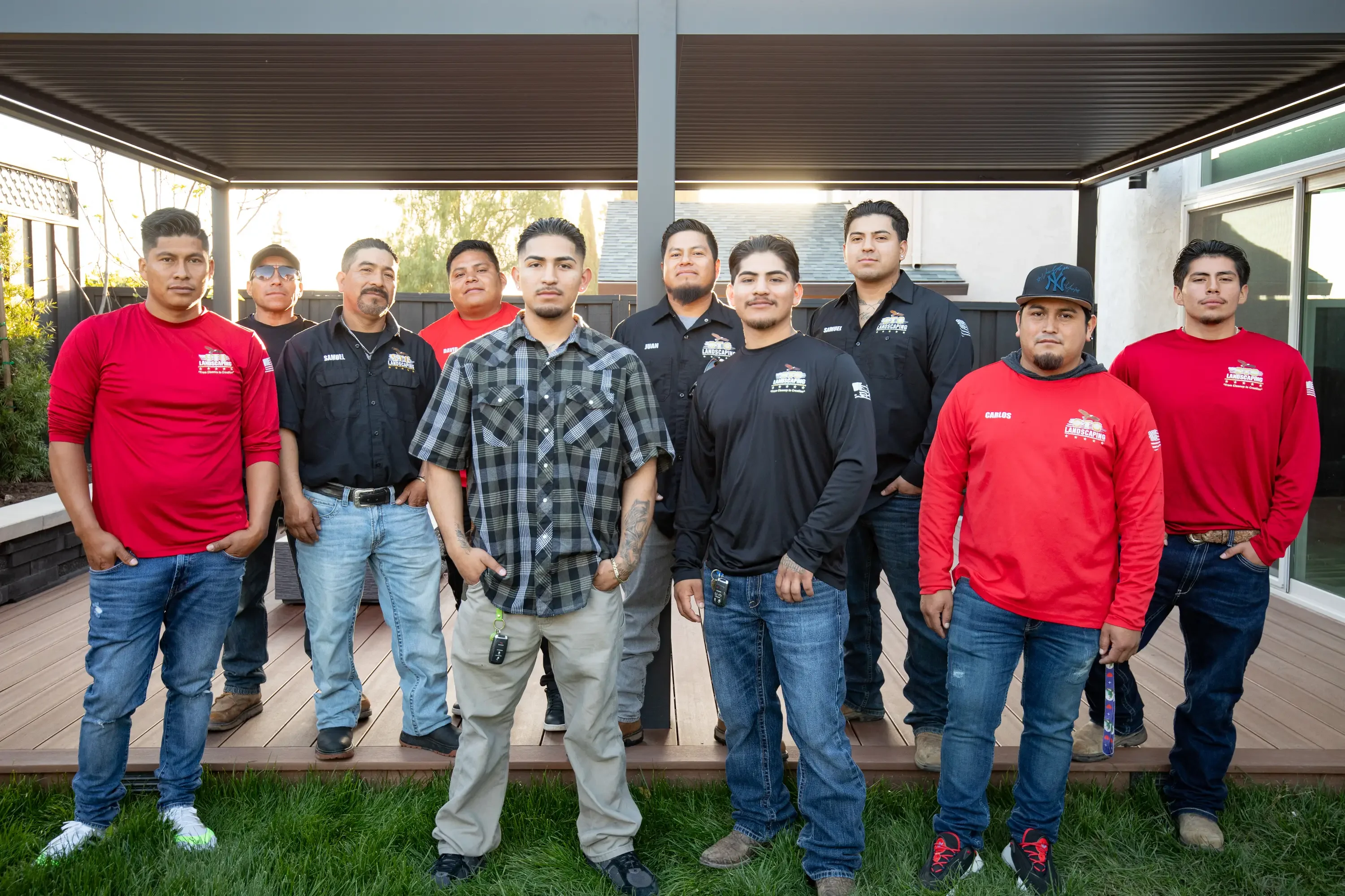 Landscaping crew with tools and equipment ready for hardscape installation work on a residential property.