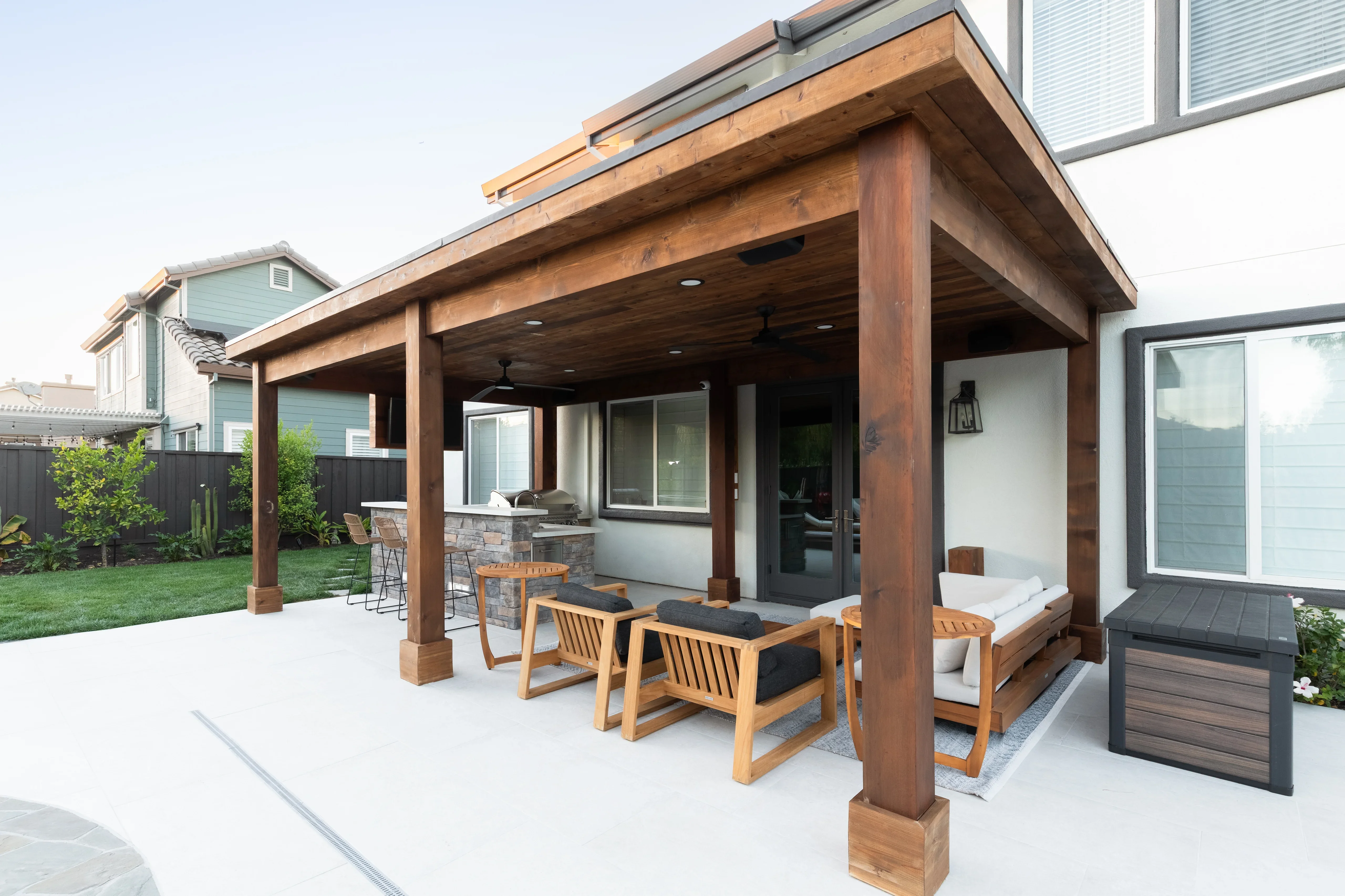Wood pergola with stone kitchen, concrete patio, and wooden beam construction