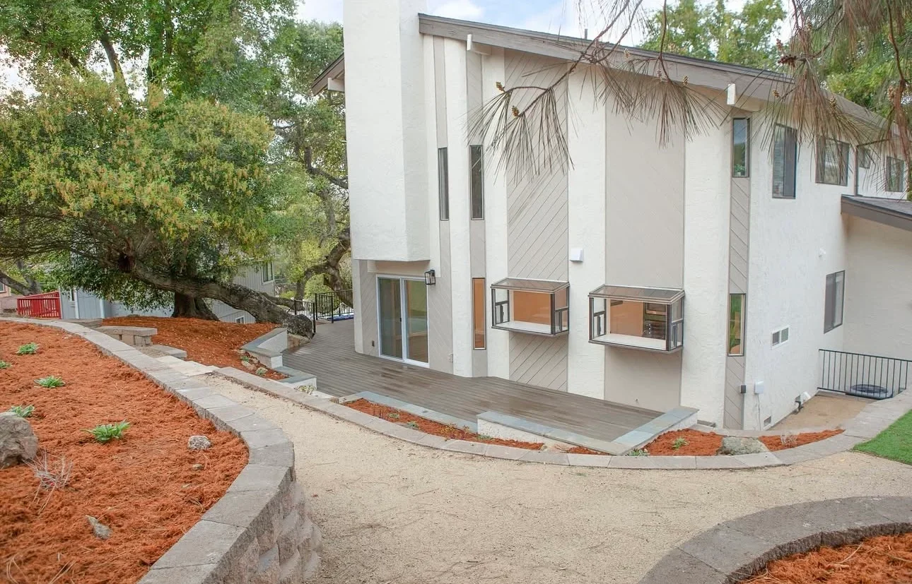 Modern home with new mulch beds, concrete edging, and gravel pathways in Morgan Hill
