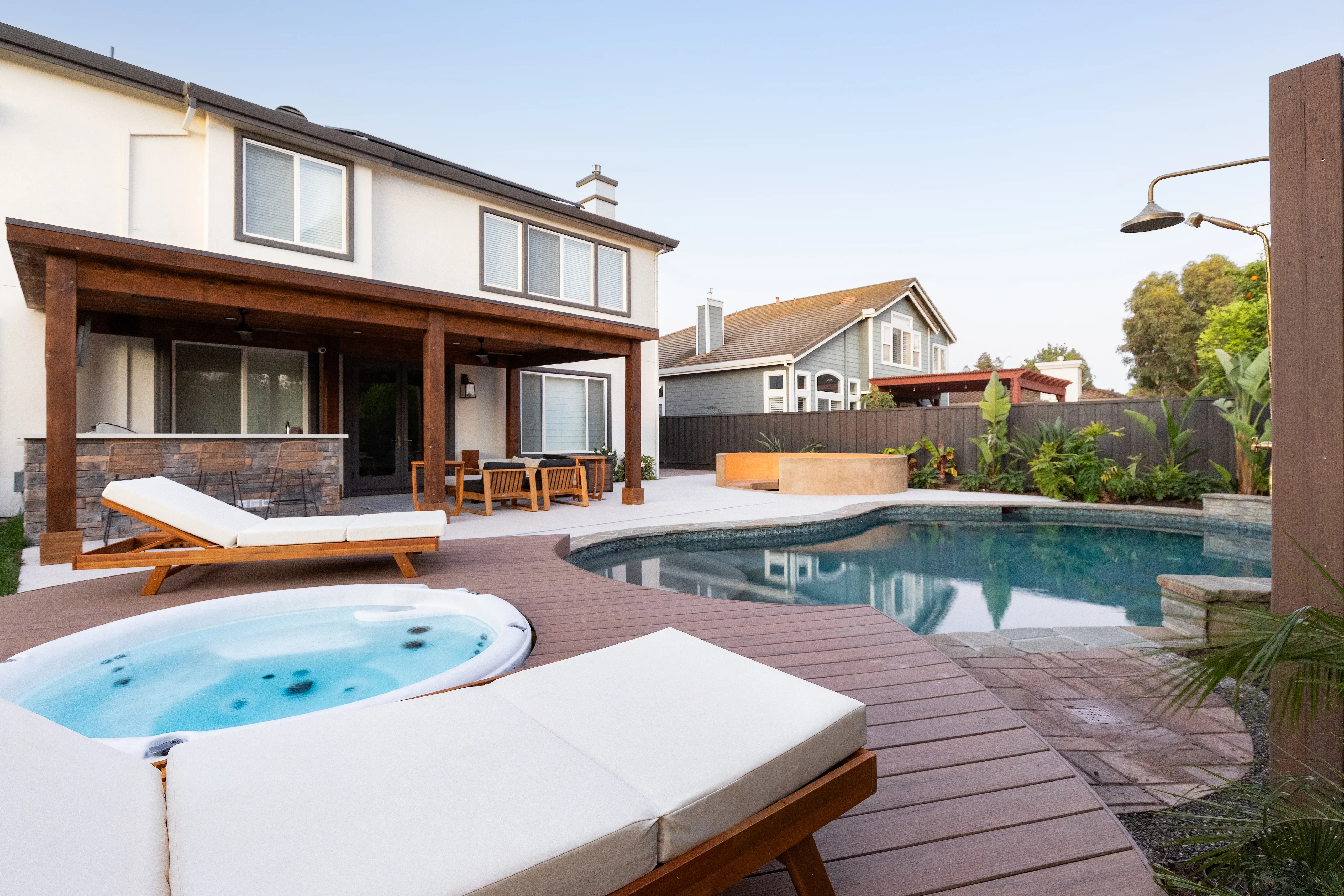 Composite deck with pool, spa, lounge chairs, and modern landscape planting