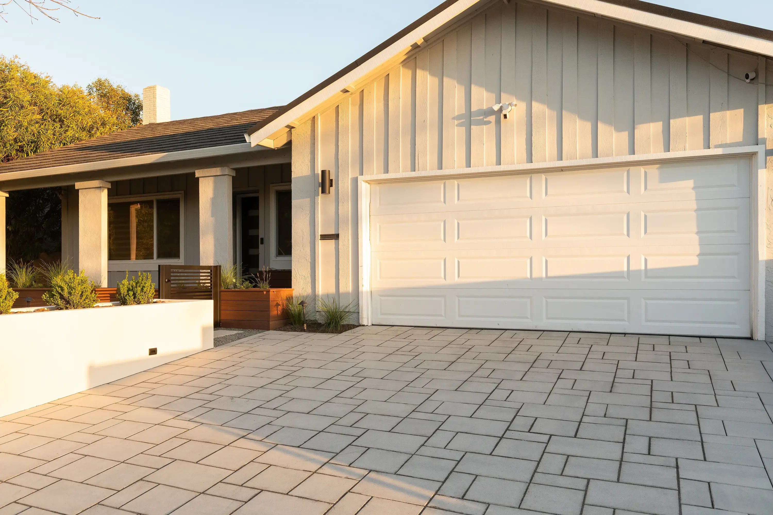 Modern home with newly installed paver driveway and patio in herringbone pattern